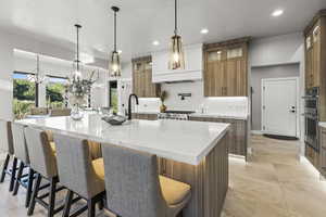 Kitchen with a kitchen breakfast bar, backsplash, appliances with stainless steel finishes, and a large island