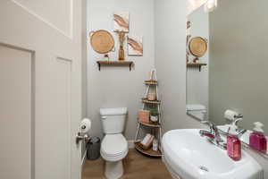 Bathroom with hardwood / wood-style flooring, sink, and toilet