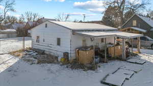 Snow covered house with a carport