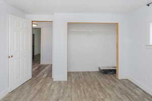 Unfurnished bedroom featuring a closet and light wood-type flooring