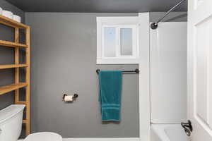 Bathroom featuring toilet and bathing tub / shower combination