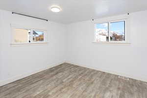 Empty room with hardwood / wood-style flooring