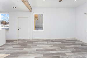 Empty room with ceiling fan and light hardwood / wood-style floors