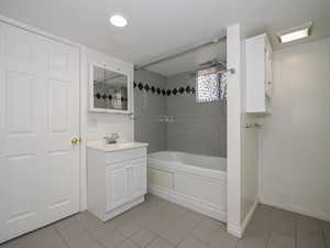 Bathroom with tiled shower / bath, vanity, and tile patterned floors