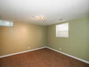 Empty room featuring a textured ceiling and carpet flooring