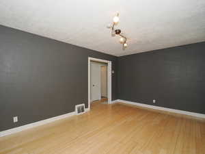 Spare room with light hardwood / wood-style floors and a textured ceiling