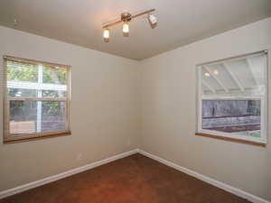 Empty room with carpet and rail lighting