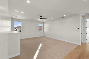 Empty room featuring ceiling fan and light wood-type flooring