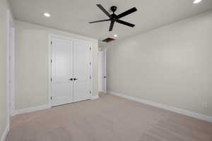 Bedroom with ceiling fan and light colored carpet