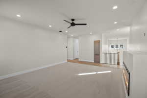 Unfurnished room featuring ceiling fan with notable chandelier