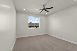 Empty room featuring light carpet and ceiling fan