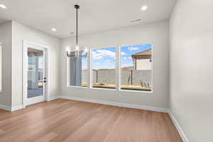 Dining area with light hardwood / wood-style floors and a chandelier