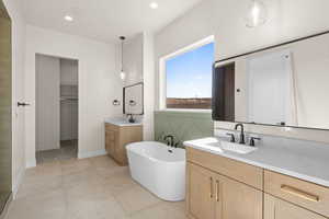 Primary bathroom featuring vanity, tile patterned flooring, and a tub