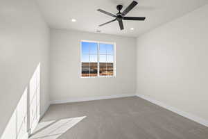 Carpeted empty room featuring ceiling fan