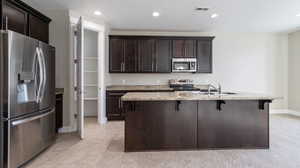 Kitchen with a kitchen breakfast bar, appliances with stainless steel finishes, sink, and an island with sink