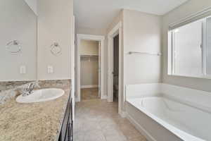 Bathroom with tile patterned floors, a bathtub, vanity, and toilet