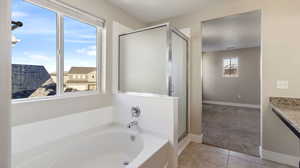 Bathroom with tile patterned floors, vanity, and plus walk in shower