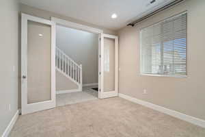 Spare room with light colored carpet and french doors