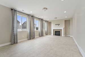 Unfurnished living room featuring light tile patterned floors and a tile fireplace