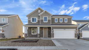 Craftsman-style home with a garage and cooling unit