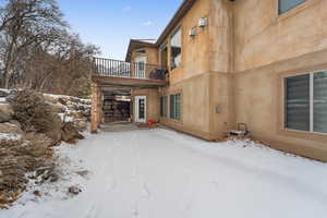 View of snow covered exterior with a balcony