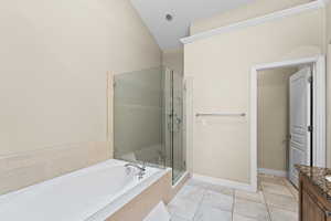 Bathroom featuring plus walk in shower, tile patterned flooring, lofted ceiling, and vanity