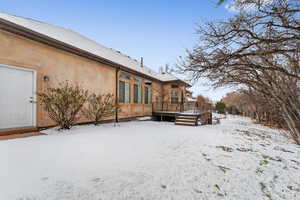 Snow covered property with a wooden deck