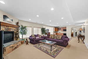 Living room featuring light colored carpet and a fireplace