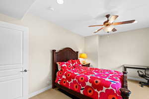 Carpeted bedroom featuring ceiling fan