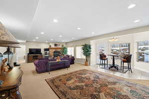 Living room featuring an inviting chandelier, light tile patterned floors, and a fireplace