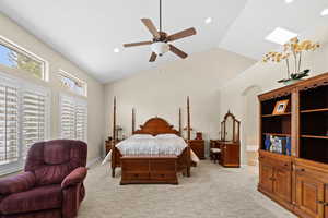 Bedroom with ceiling fan, light colored carpet, and lofted ceiling