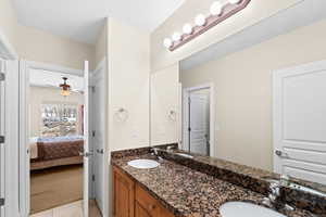 Bathroom featuring ceiling fan, vanity, and tile patterned flooring