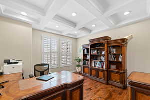 Home office featuring dark wood-type flooring, beam ceiling, and coffered ceiling