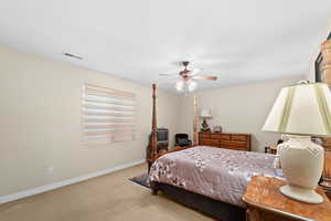 Bedroom with ceiling fan and light colored carpet