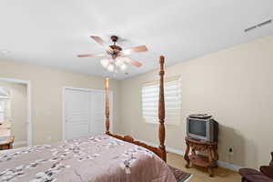 Carpeted bedroom with ceiling fan and a closet