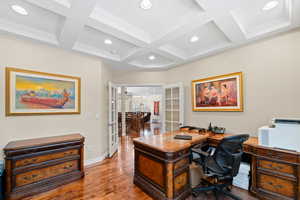 Office space featuring coffered ceiling, hardwood / wood-style floors, french doors, and beamed ceiling