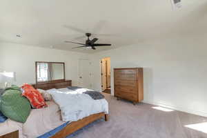 Bedroom with ceiling fan and light colored carpet