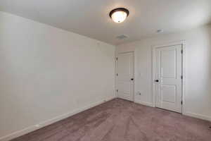 Unfurnished bedroom with light carpet