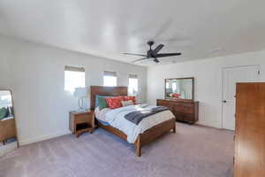 Bedroom with ceiling fan and light carpet