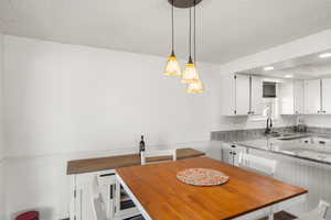 Dining room featuring sink and a textured ceiling