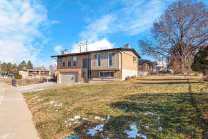 View of front of home with a front yard and a garage