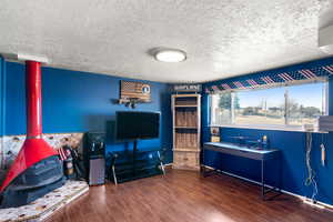 Interior space with a textured ceiling and dark hardwood / wood-style floors