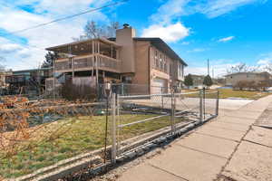 View of home's exterior featuring a lawn, a balcony, and a garage