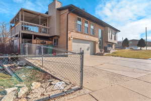 View of property exterior with a garage and a balcony