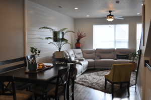 Living room with ceiling fan and hardwood / wood-style floors