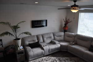 Living room with dark wood-type flooring and ceiling fan