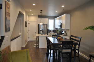 Dining space featuring dark wood-type flooring and sink