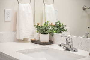 Bathroom with vanity and tasteful backsplash