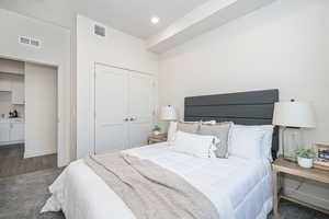 Bedroom with dark wood-type flooring and a closet