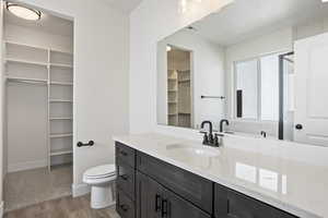 Bathroom with toilet, wood-type flooring, and vanity